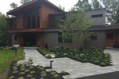 A deconstructed main entrance featuring linear fountain grasses