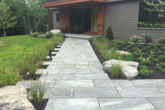 The boulders are cut into the walkway edge to look like the native ledge outcrops on site.